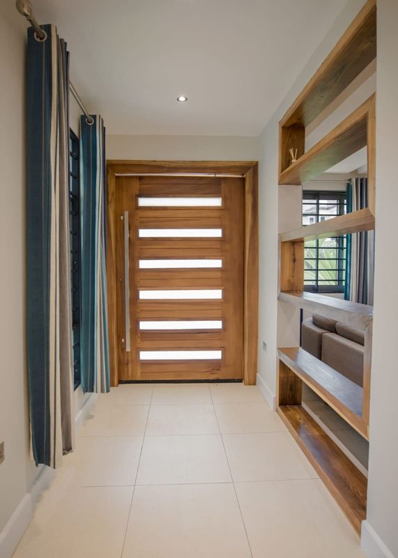 Entrance hall with a timber pivot door and built-in shelving